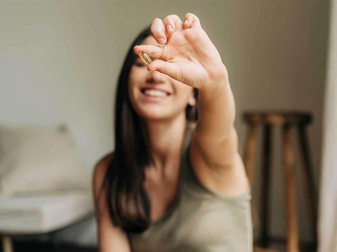 Frau mit einer Omega-3-Kapsel